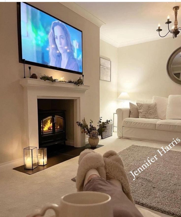 a living room filled with furniture and a flat screen tv mounted above a fire place