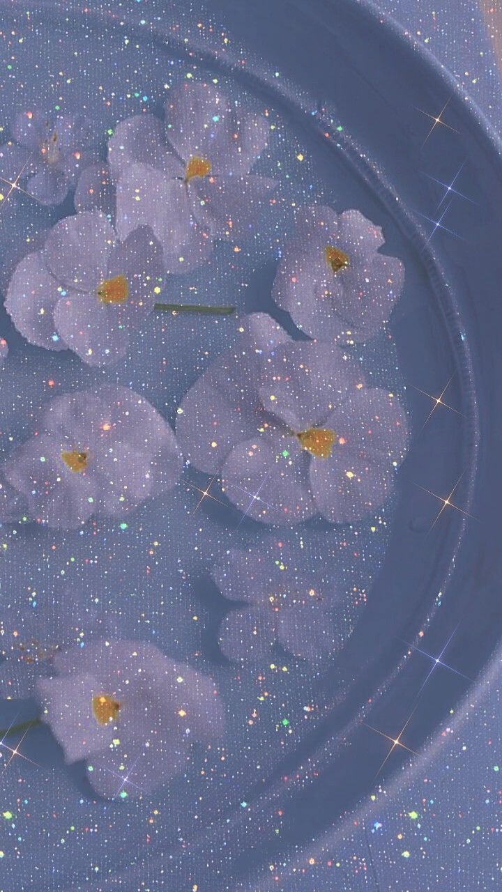 white flowers floating in water with sparkles on the bottom and blue surface behind them