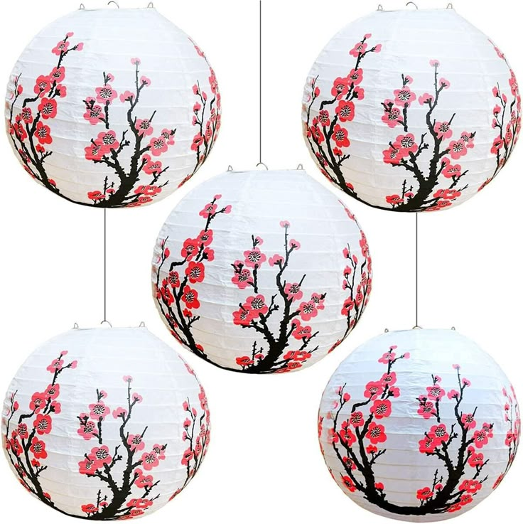 four white paper lanterns with red flowers on them