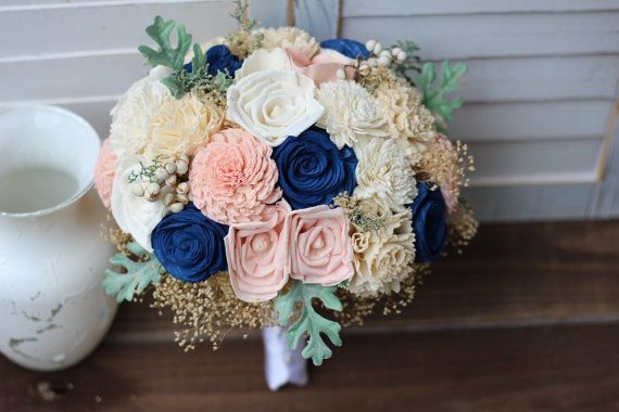 a bridal bouquet sitting next to a white vase