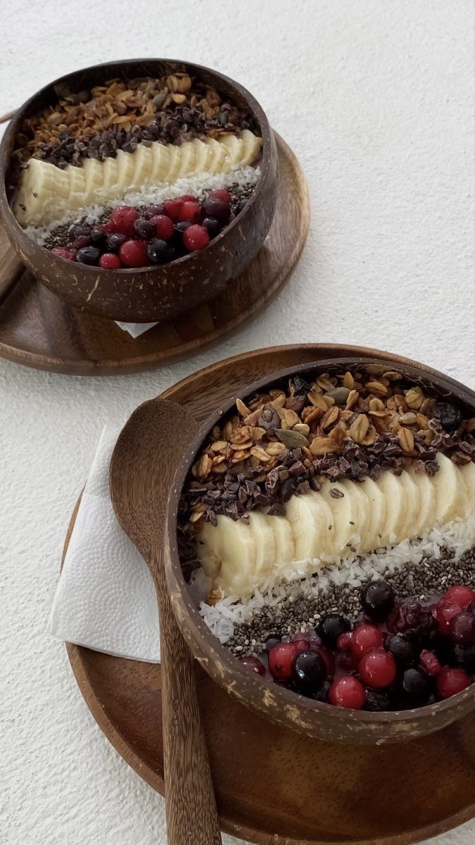 two desserts with fruit and nuts in wooden bowls