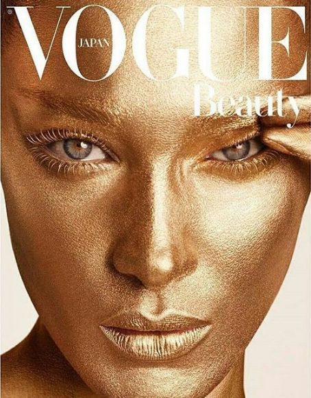 an image of a woman's face on the cover of a magazine with gold makeup