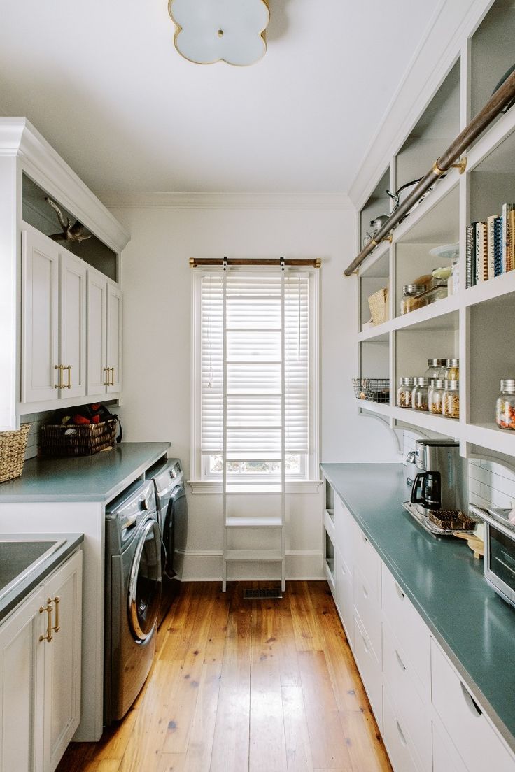 a kitchen with wood floors and white cabinets