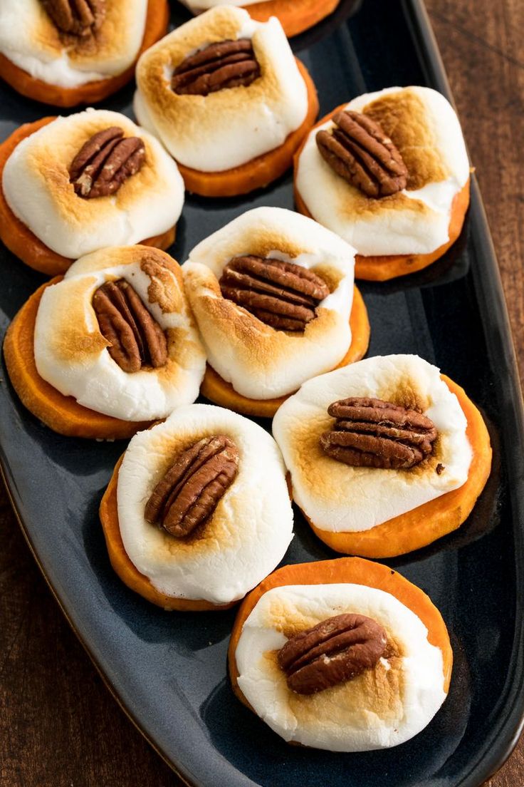 a tray filled with mini pumpkins covered in cream cheese and pecans on top