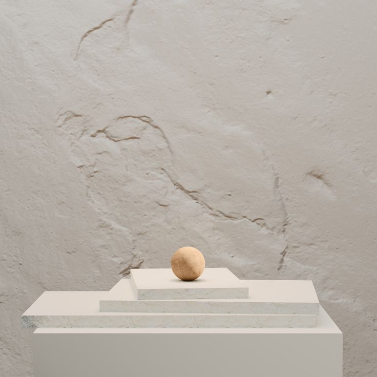 an object is sitting on top of a white pedestal in front of a gray wall