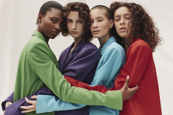 four models in colorful clothing posing for the camera with their arms around each other's shoulders