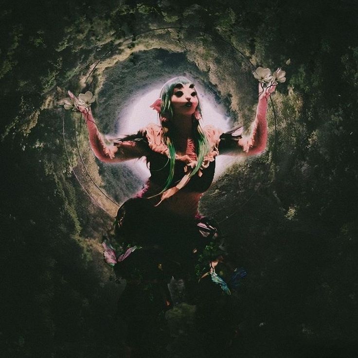 a woman with green hair is standing in the middle of a tunnel holding her hands up