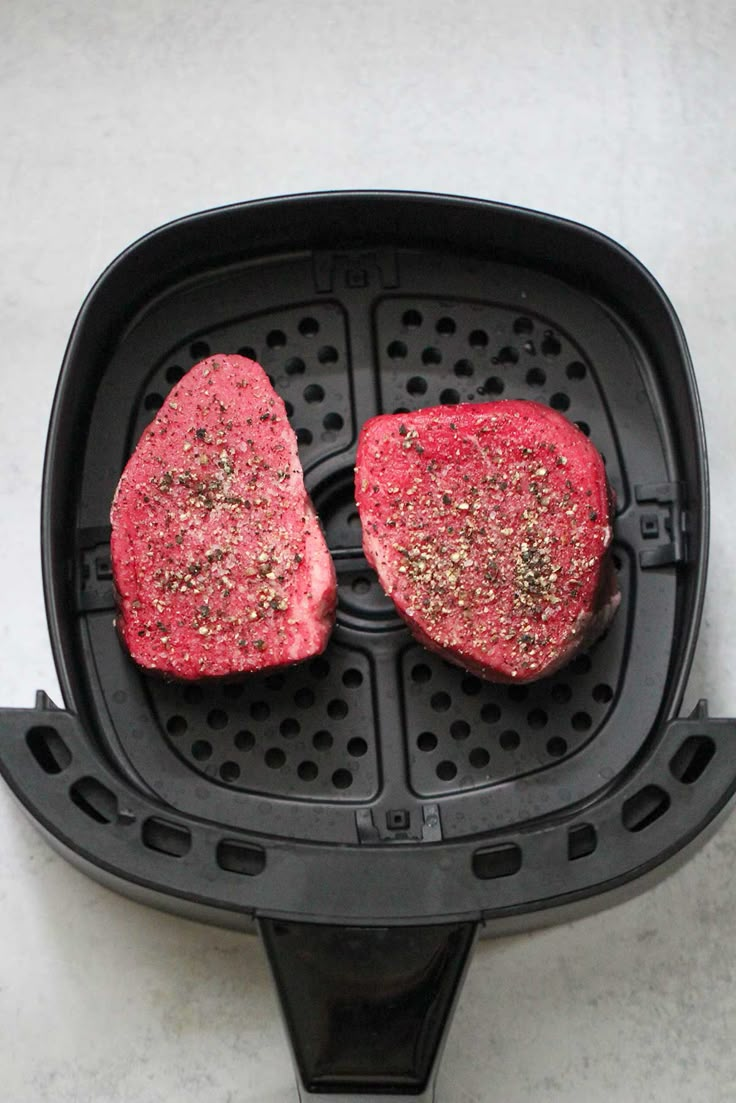 two raw steaks are in a deep fryer