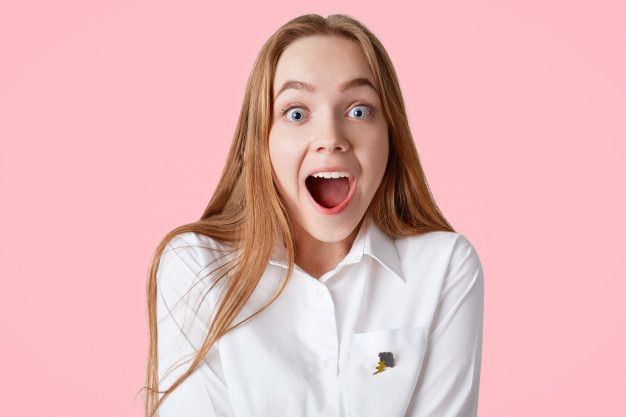 a woman making a funny face while wearing a white shirt