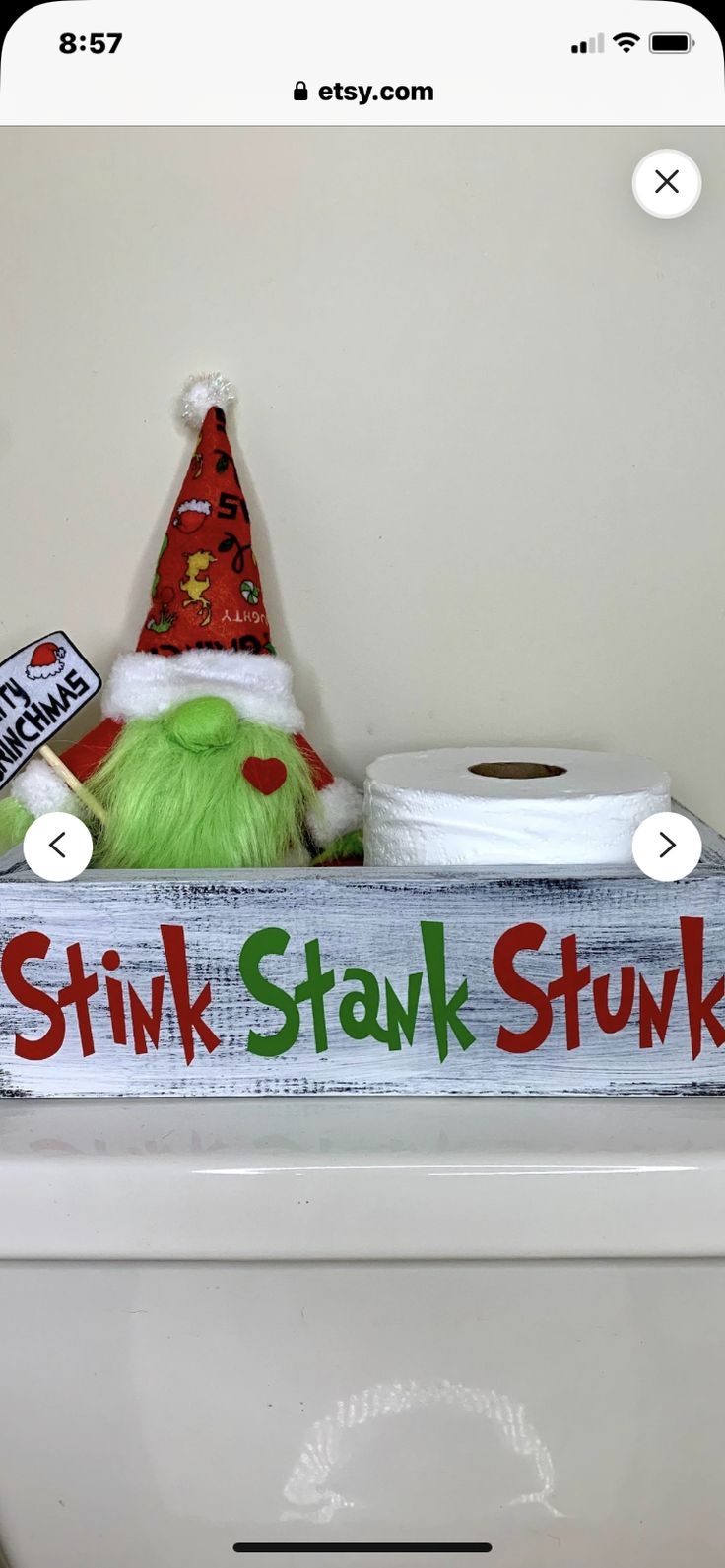 a toilet with a sign that says stink stark stuck on it and a green elf hat