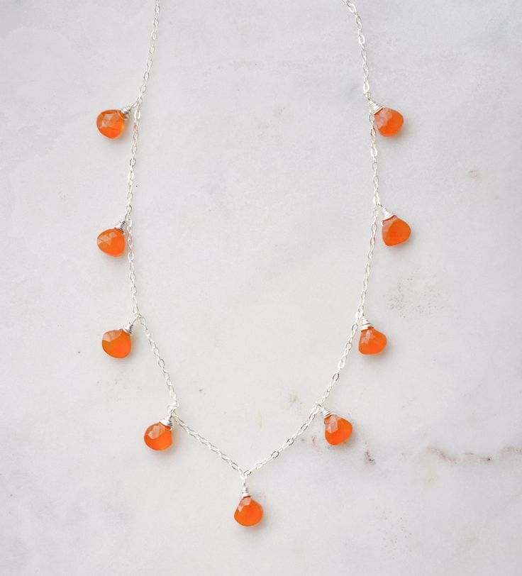 Embrace the magic of Carnelian with our natural multi-teardrop necklace! Handcrafted with authentic Carnelian gems, this necklace is perfect for that classic look. This piece plays well with others and loves to be layered! This stone necklace will be hand-made in your choice of sterling silver or 14k gold filled. Crystals will vary slightly in color, with some containing reddish banding, while others will be solid orange or orange-red.Carnelian Meaning: Carnelian, an orange variety of Quartz, is Handmade Orange Teardrop Necklace, Orange Faceted Carnelian Necklaces, Orange Faceted Carnelian Necklace, Carnelian Meaning, Energy Booster, Solid Orange, Natural Gemstone Necklace, Red Carnelian, Carnelian Necklace