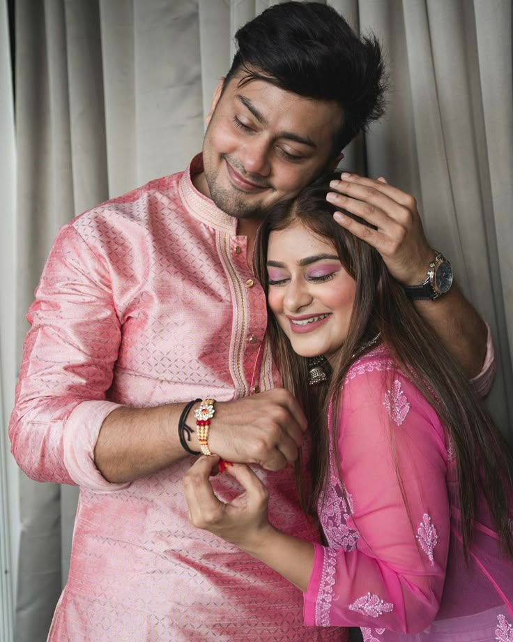 a man in a pink outfit standing next to a woman