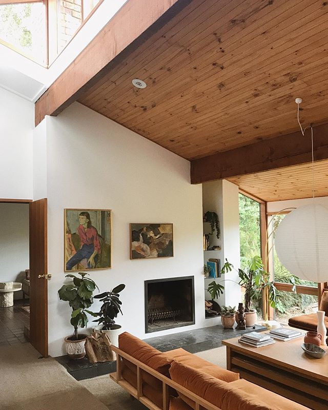 a living room filled with furniture and a fire place in the middle of an open floor plan