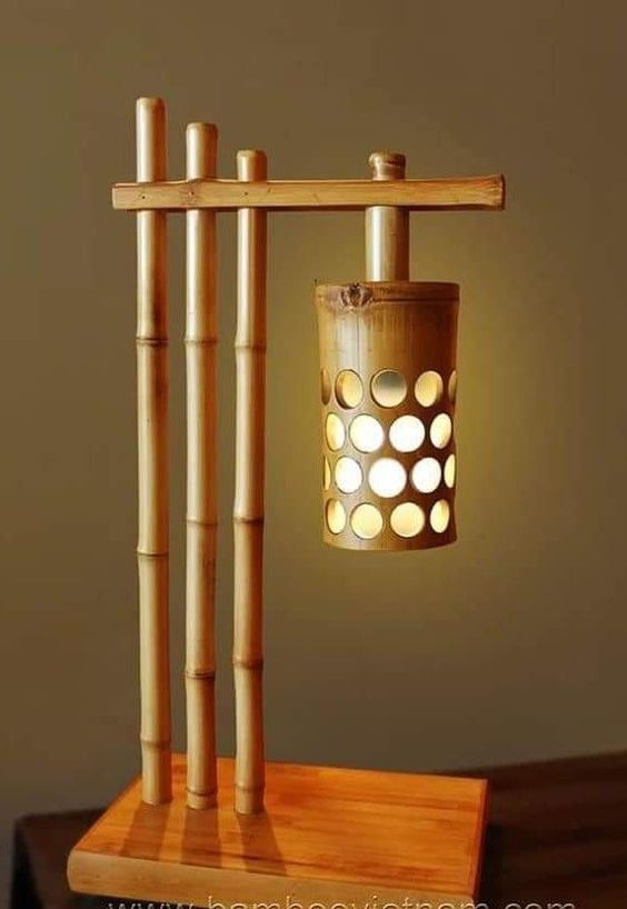 a lamp made out of bamboo sticks on top of a wooden table