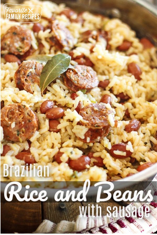 a pan filled with rice and sausages on top of a wooden table