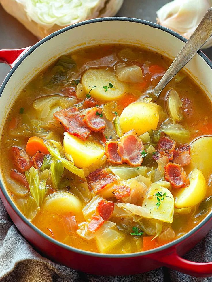 a red pot filled with soup and vegetables