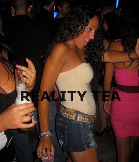 a group of young women standing next to each other at a party with drinks in their hands