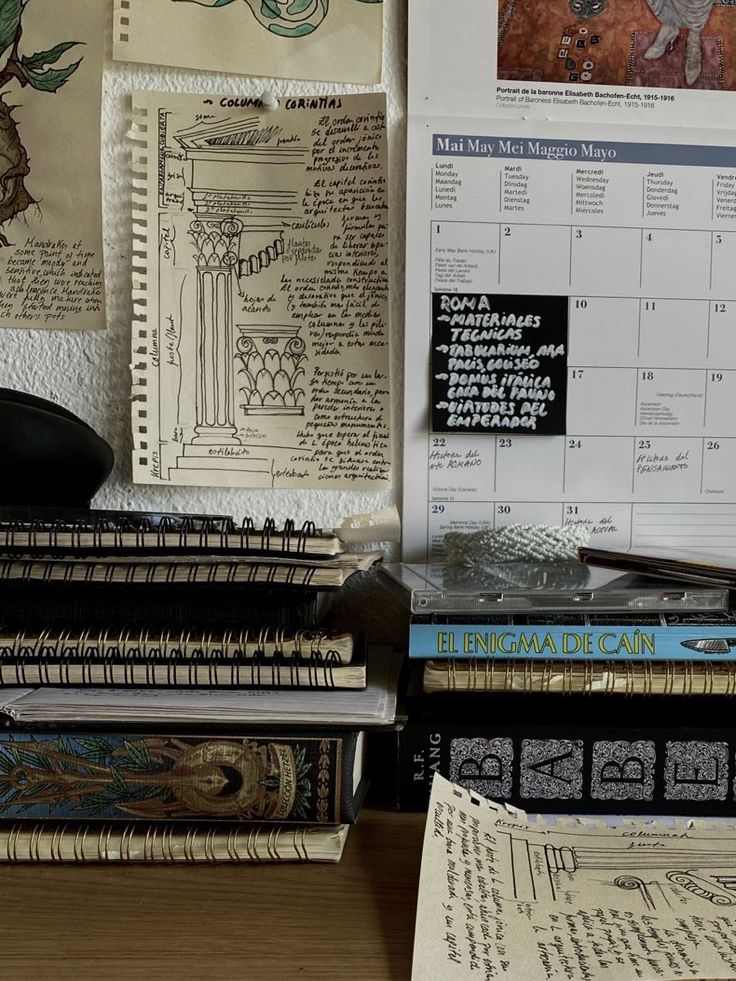 many books are stacked next to each other on a desk with a mouse and calendar