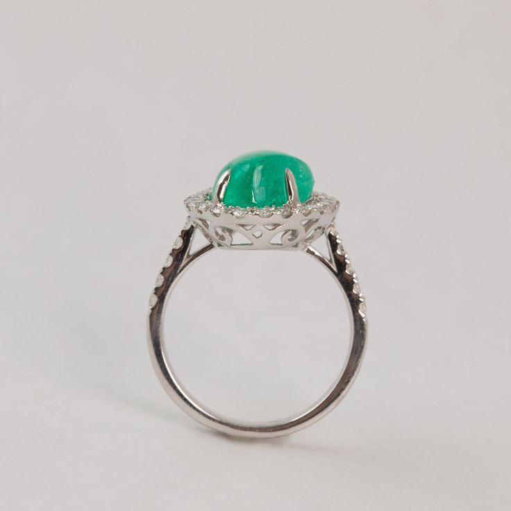 This buttery smooth cabochon emerald is wrapped snuggly in melee diamonds. Materials - 18k White Gold, Emerald, Diamond Weights - 5.17 Emerald, 0.60ct Diamond Size - 6.5 Luxury Emerald Cabochon Ring With Diamonds, Formal Emerald Cabochon Diamond Ring, Luxury Emerald Ring With Oval Cabochon Center Stone, Emerald Ring With Oval Cabochon Center Stone, Green Oval Cabochon Emerald Ring For Wedding, Green Emerald Oval Cabochon Ring For Wedding, Emerald Oval Cabochon Ring With Center Stone, Oval Cabochon Emerald Ring With Center Stone, Round Cabochon Emerald Ring