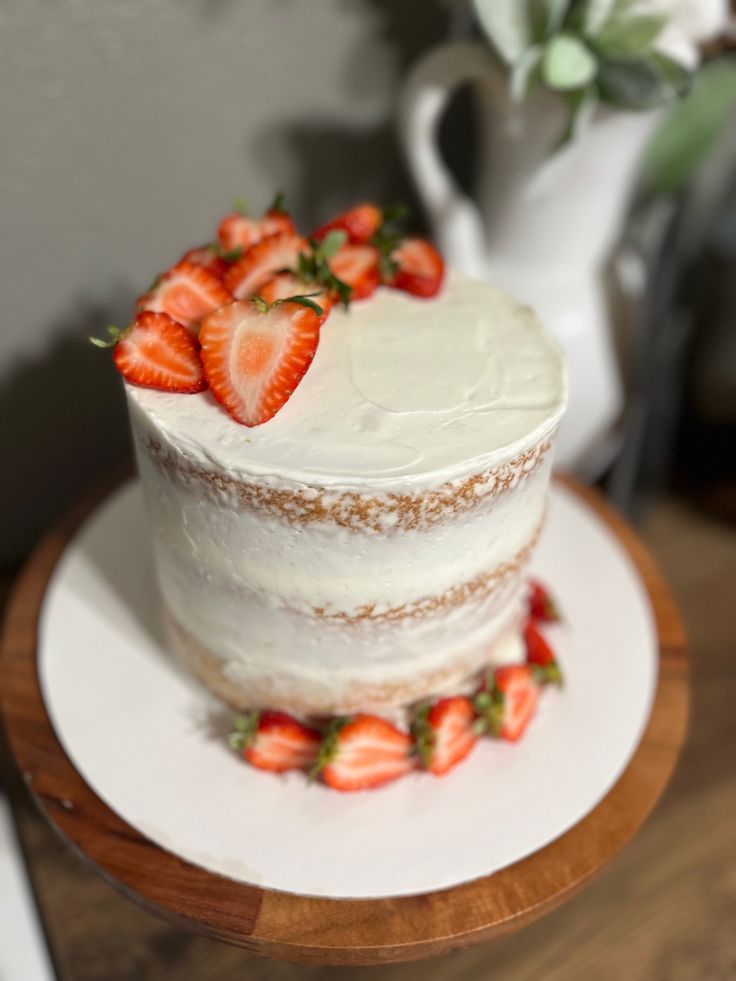 there is a white cake with strawberries on it