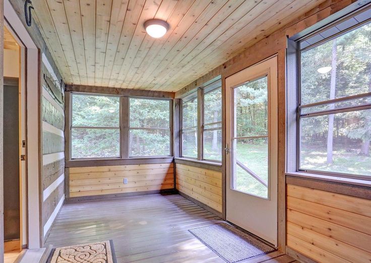 an empty room with wood paneling and windows