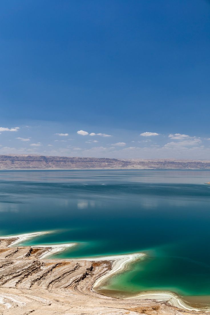 the water is very blue and green in this desert area with white sand on the shore