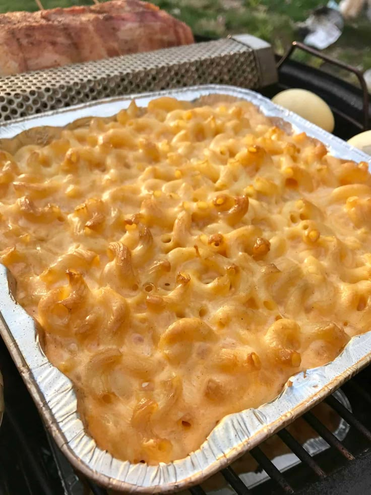 an uncooked macaroni and cheese casserole is cooking on the grill