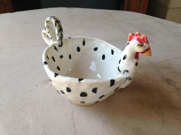 a ceramic chicken bowl sitting on top of a table