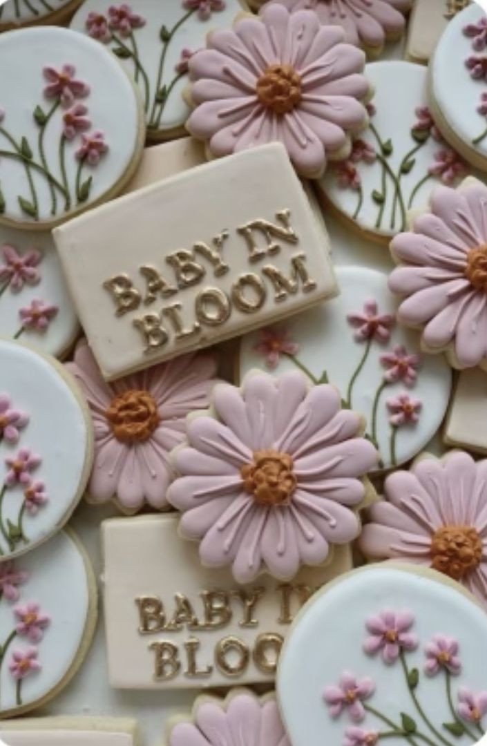 baby in bloom cookies with pink flowers and words on them are displayed for the camera