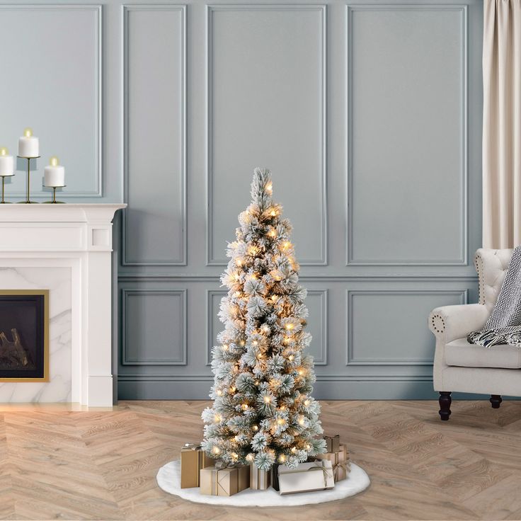 a decorated christmas tree in the corner of a room with blue walls and white trimmings