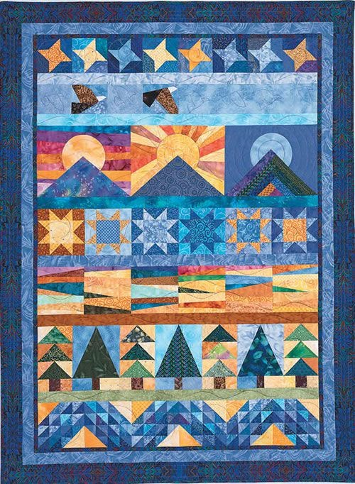 a quilted wall hanging with stars and mountains in the sky, on top of a blue