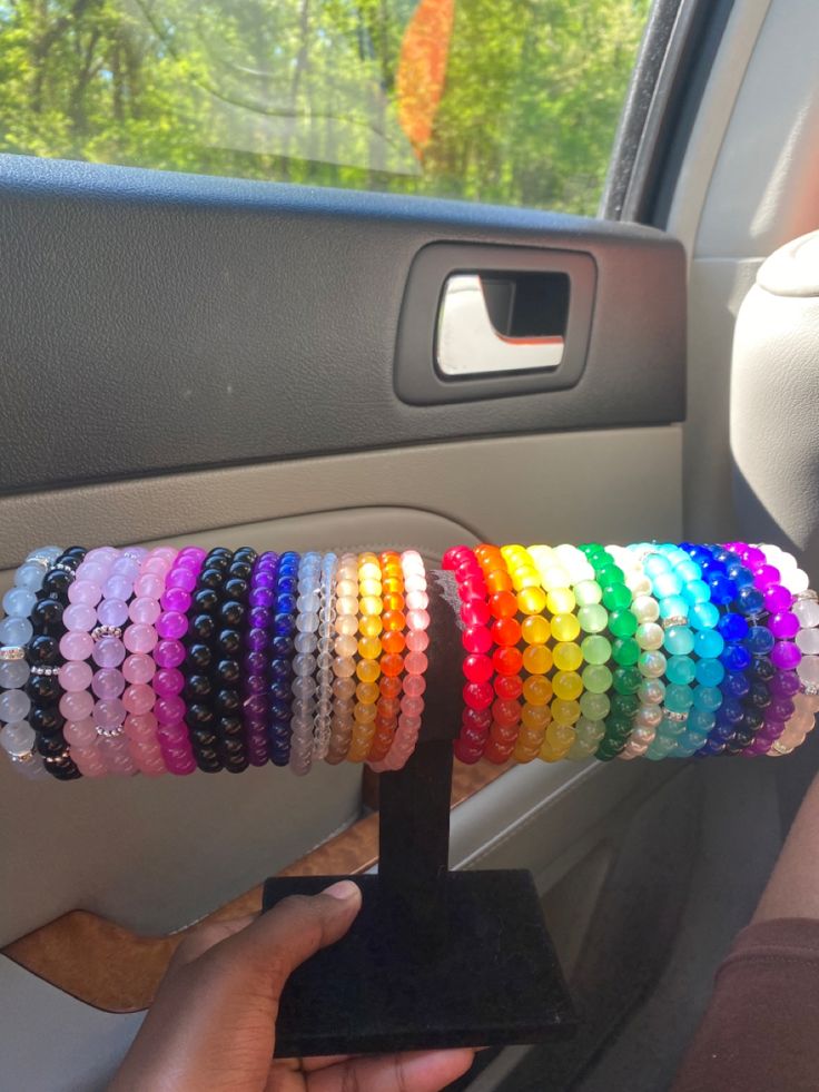 a person is holding a bunch of bracelets in their hand while sitting in the driver's seat