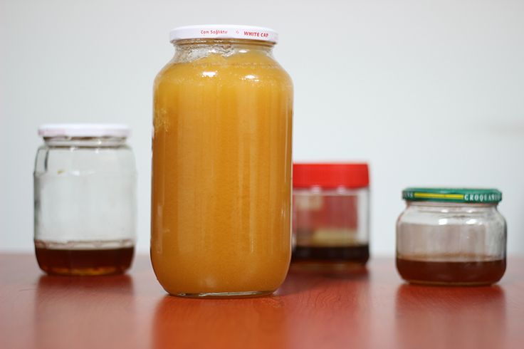 jars filled with liquid sitting on top of a wooden table