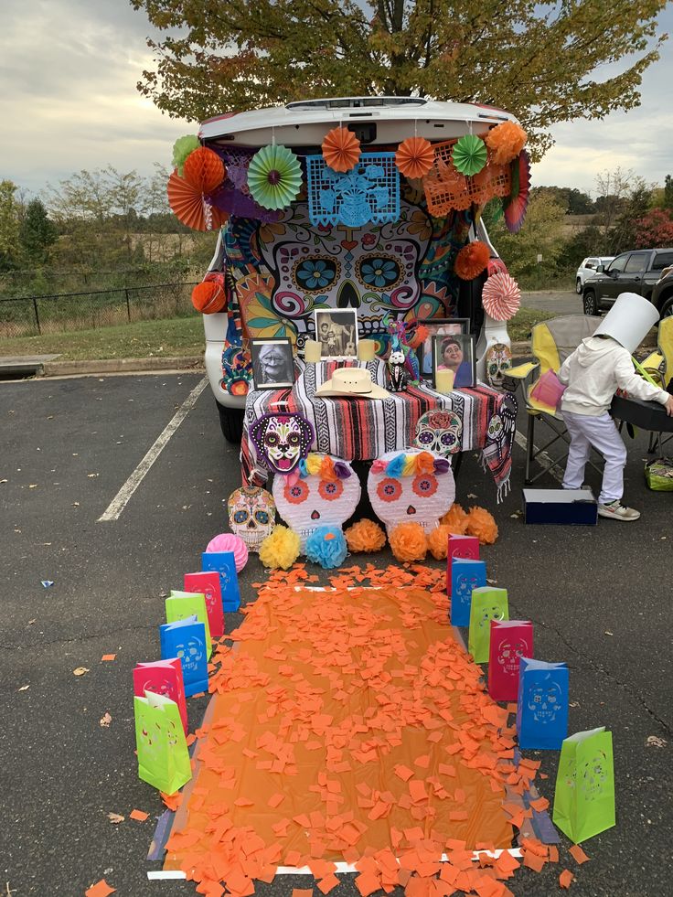 a decorated bus with decorations on the side and people standing around it in the parking lot