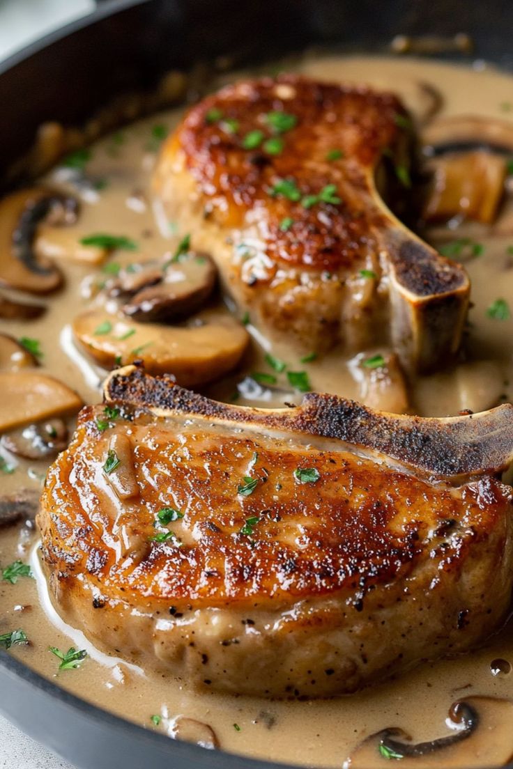 some meat and mushrooms are cooking in a skillet on the stove with gravy