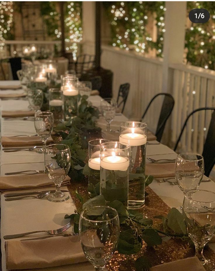 a long table is set with candles and place settings for dinner guests to sit at