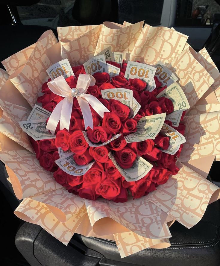 a bouquet of red roses in the shape of a heart with money notes on it