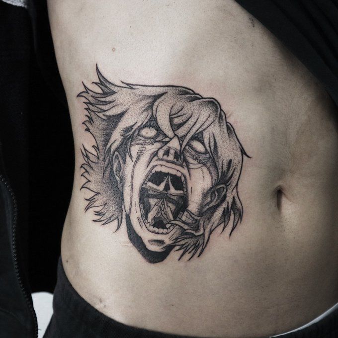 a woman's stomach with an angry face tattoo on her side, and the lower part of her abdomen