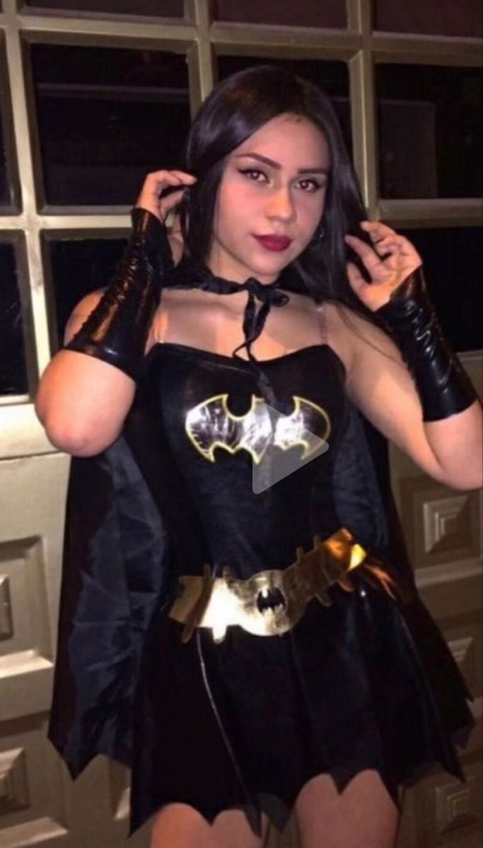 a woman dressed in a batgirl costume posing for the camera with her hands on her hips