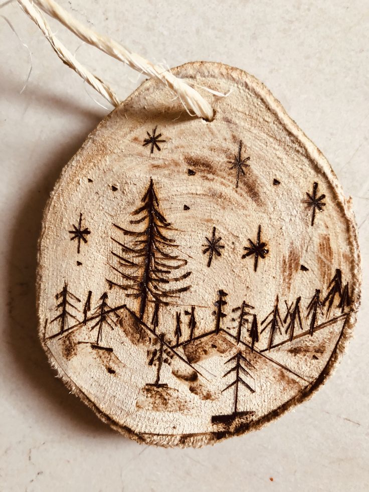 a wooden ornament with trees and stars on it