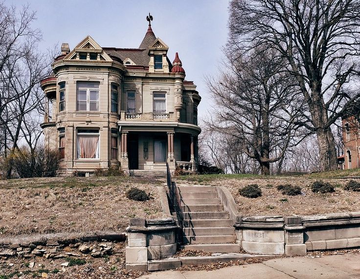 an old abandoned house with stairs leading up to it