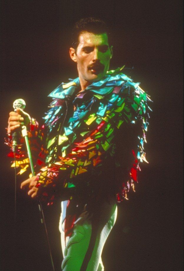 a man dressed in colorful clothing holding a microphone