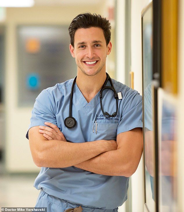 a man in scrubs standing with his arms crossed