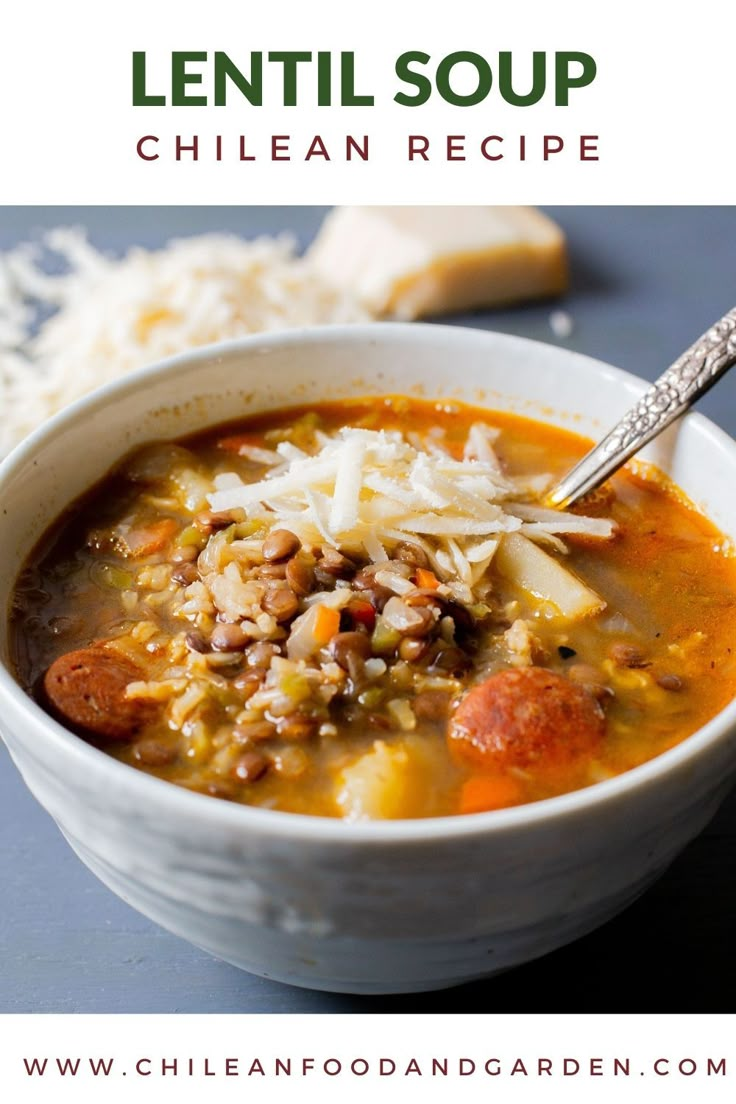 a white bowl filled with soup next to bread and grated parmesan cheese