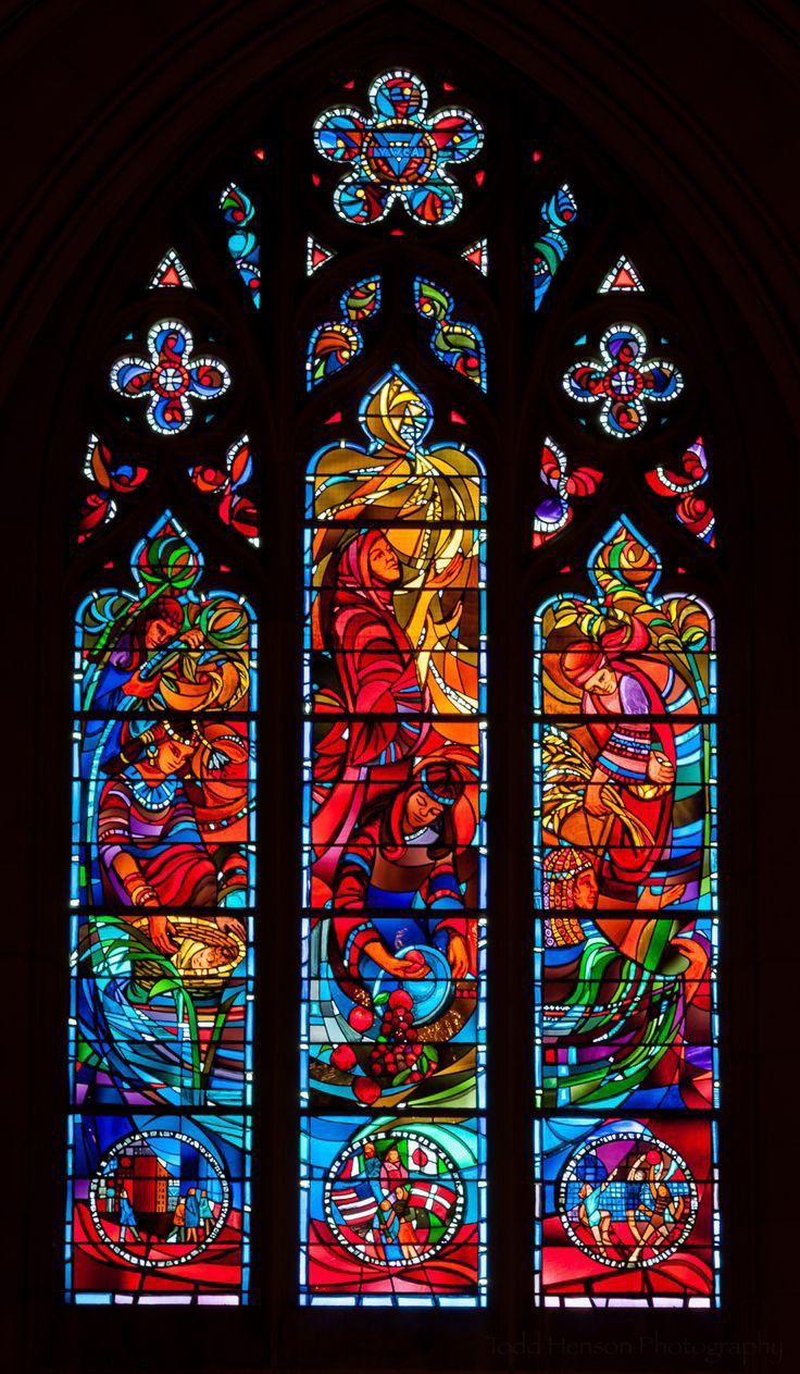 a large stained glass window inside of a church with lots of colorful designs on it