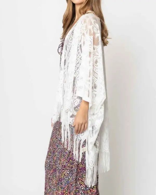 Beautiful lace kimono with fringes on the bottom. The pattern of lace is elegant and laser cut edges look gorgeous with fringes. Great for everyday outfits, beach cover-ups and more!One sizeDimensions: approximately 50 inches wide x 29 inches long100% Polyester Material Composition: 100% Polyester Bohemian Lace Beach Cover-up, Bohemian Lace Kimono For Festivals, Bohemian Lace Kimono With Lace Trim, Festival Lace Kimono With Lace Trim, Bohemian Lace Cover-up With Lace Trim, White Lace Kimono For Summer, White Lace Summer Kimono, Bohemian Lace Cover-up For Summer, Open Front Lace Trim Cover-up For Festivals