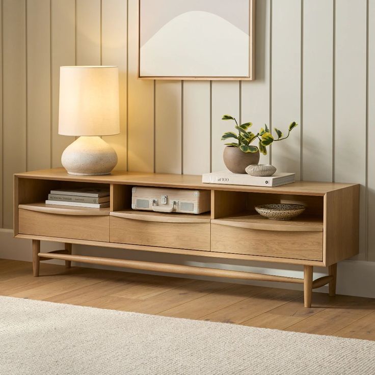 a living room with a lamp and some books on the shelf in front of it