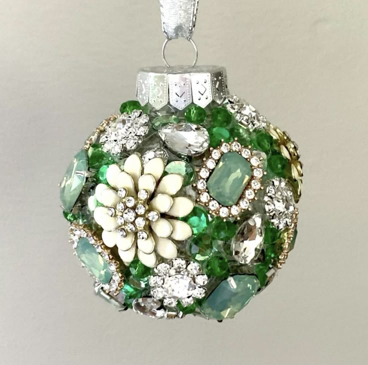 an ornament with green, white and clear stones in it's center