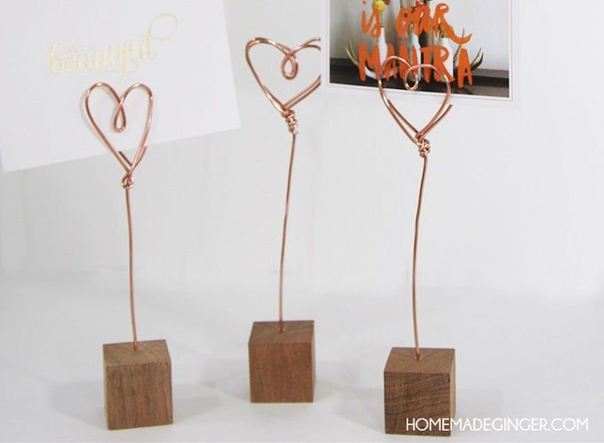 three metal hearts stand on wooden blocks in front of a card