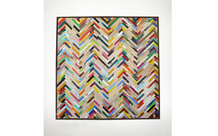 a multicolored wall hanging made out of strips of wood